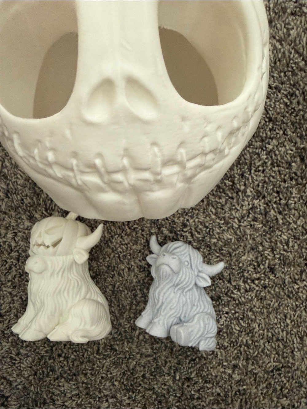 White Ceramic Skull with White and Light Gray Highland Cow Figurines
